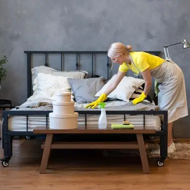 Cleaner preparing a bedroom for holiday rental guests