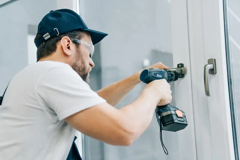 Handyman renovating and fixing a window handle